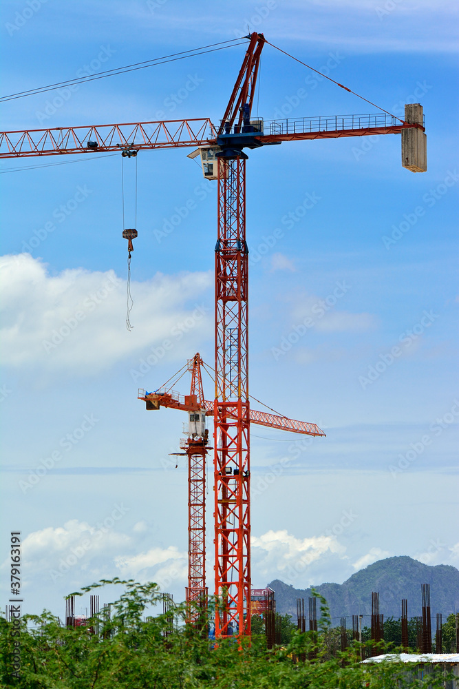 Cranes in construction site with nice blue sky in background