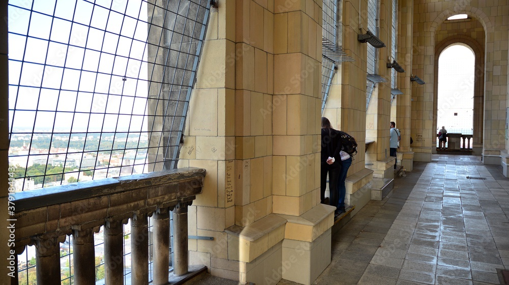 A lookout terrace on the 30th floor. People looking through barred windows on the terrace  located o