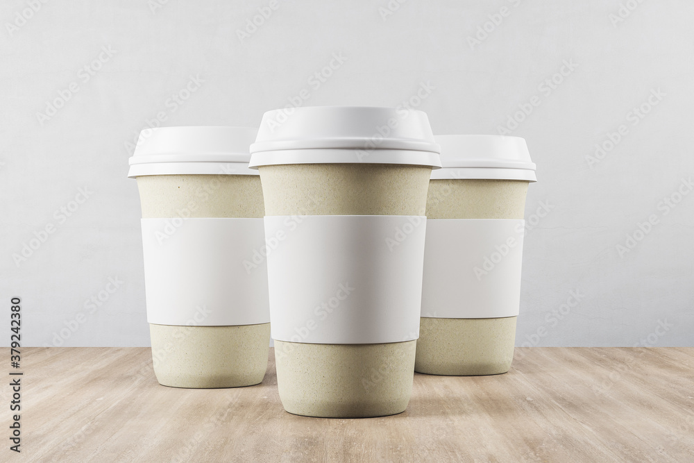 Three disposable white paper cup of coffee on wooden table.