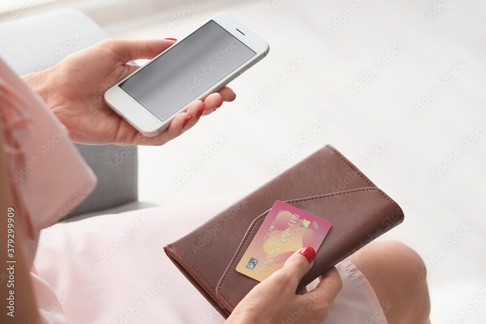 Young woman with credit card, wallet and mobile phone at home. Online shopping concept