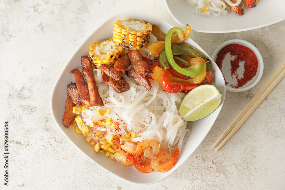 Bowl with tasty rice noodles on table