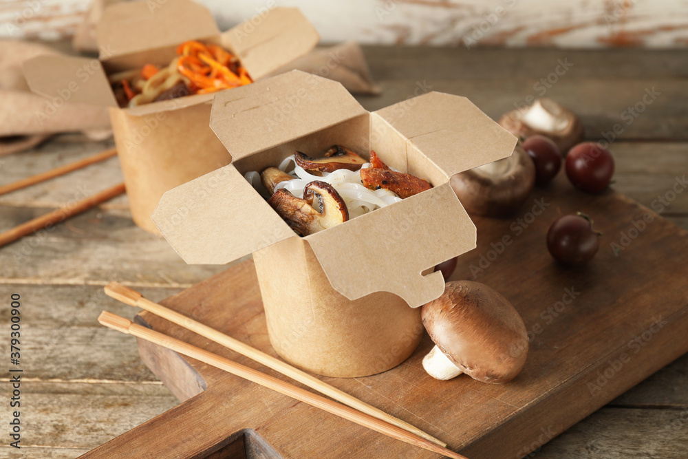 Box with tasty rice noodles on table