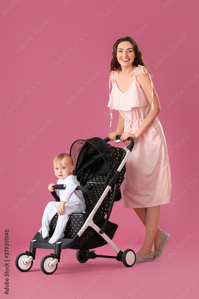 Woman and her cute baby in stroller on color background