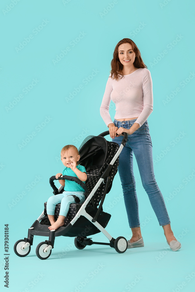 Woman and her cute baby in stroller on color background