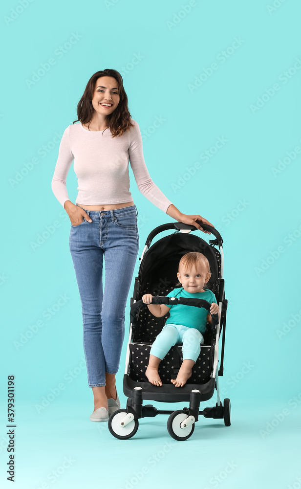 Woman and her cute baby in stroller on color background