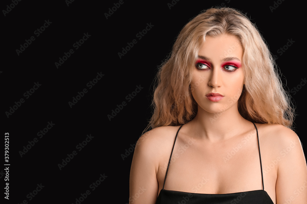 Young woman with beautiful eyeshadows on dark background