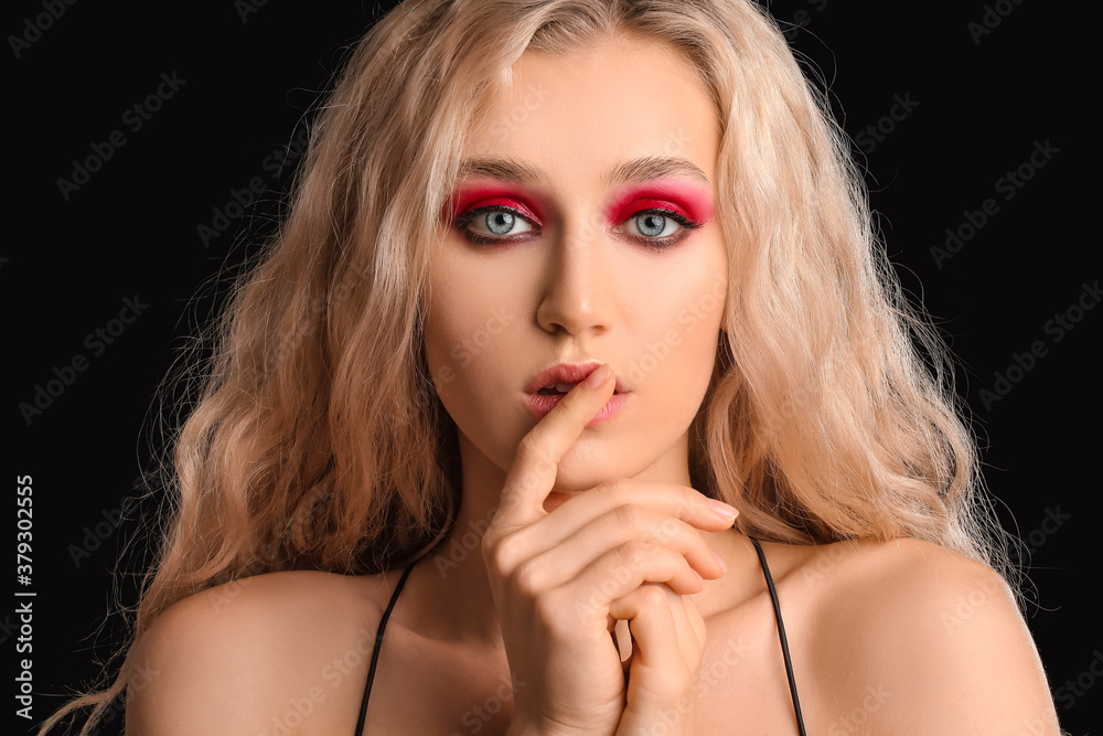 Young woman with beautiful eyeshadows on dark background