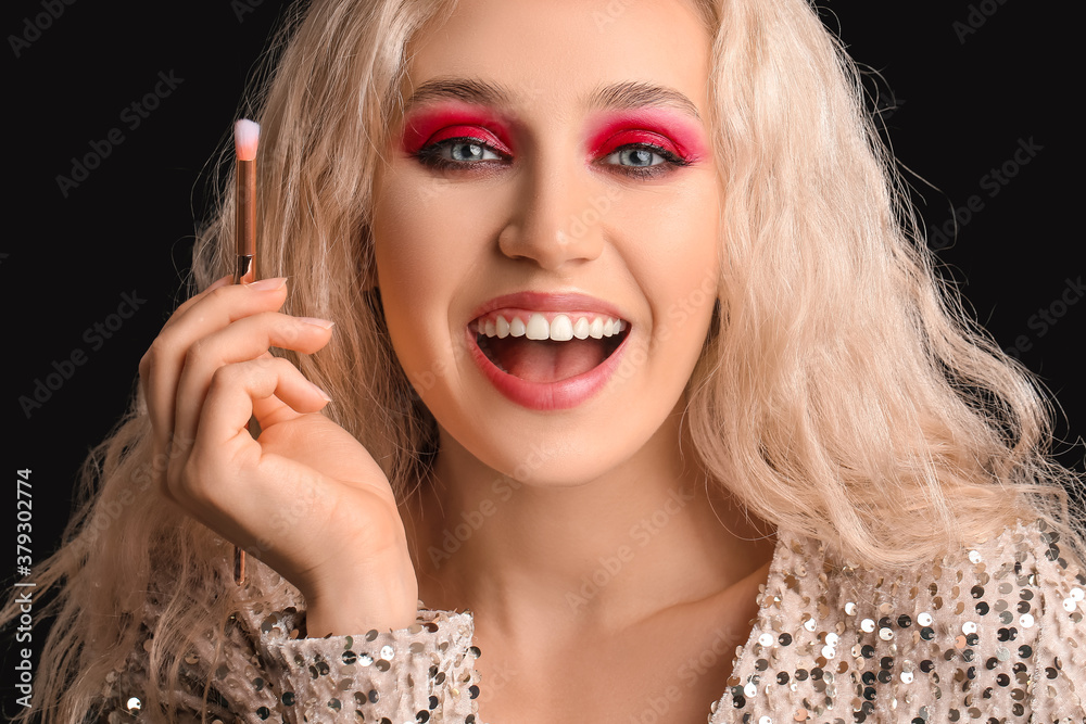 Young woman with beautiful eyeshadows on dark background