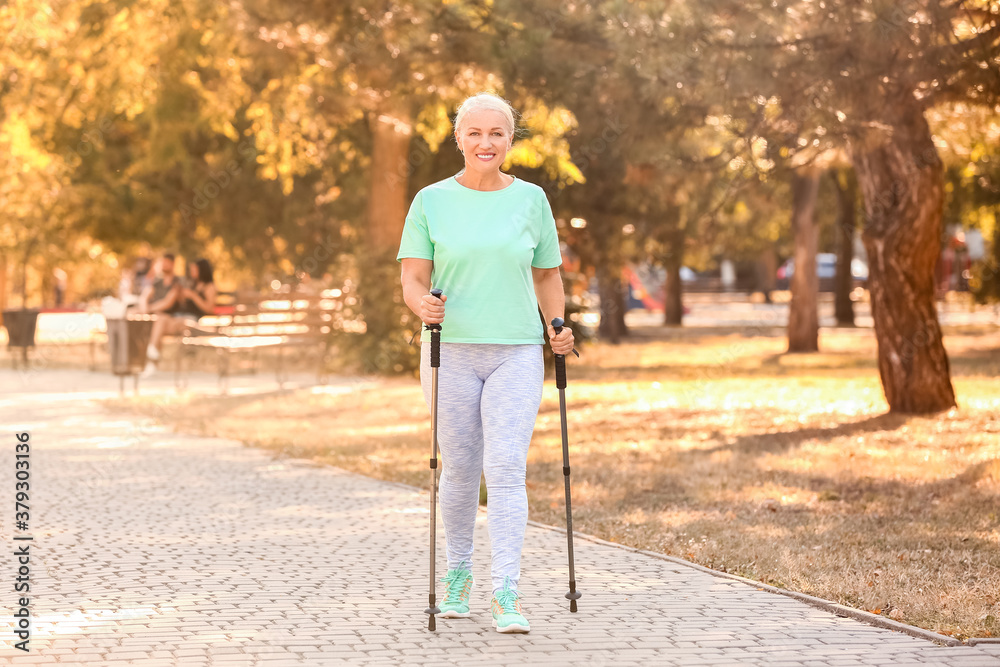 Mature woman with walking poles outdoors