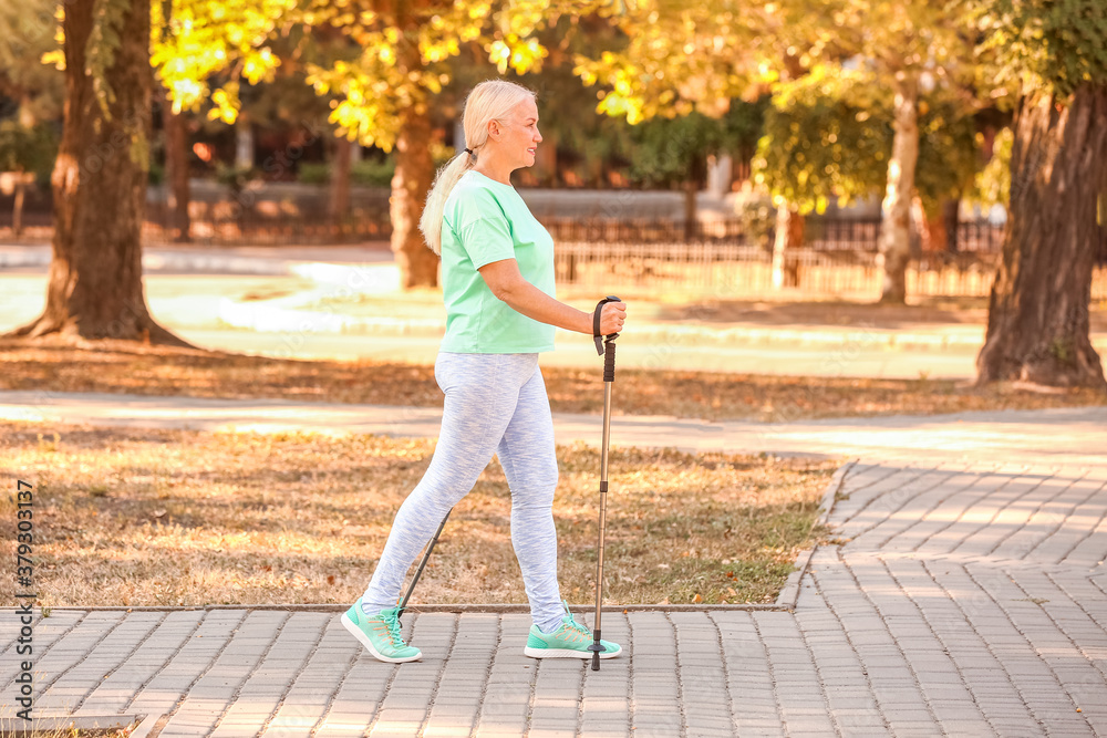 Mature woman with walking poles outdoors