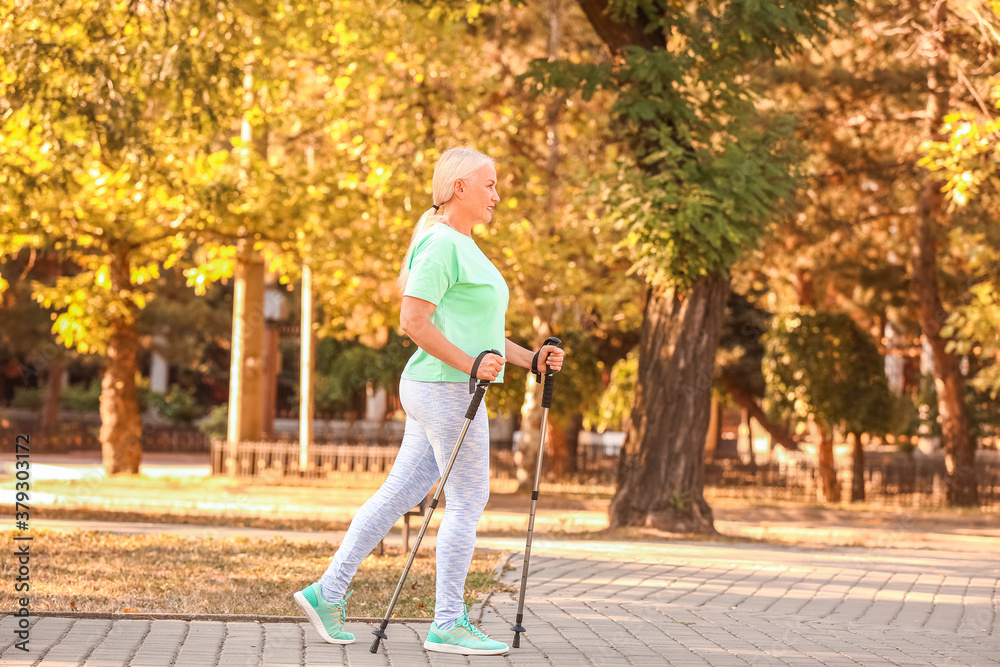 Mature woman with walking poles outdoors