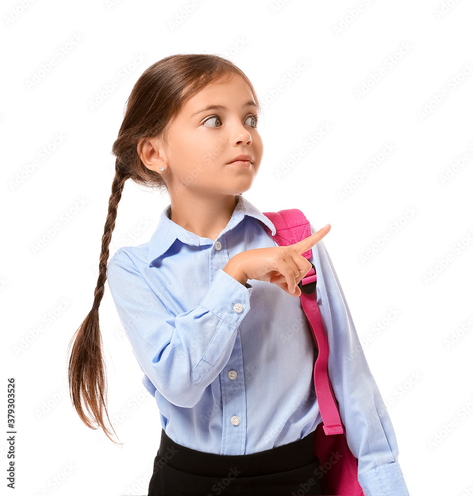 Little schoolgirl pointing at something on white background