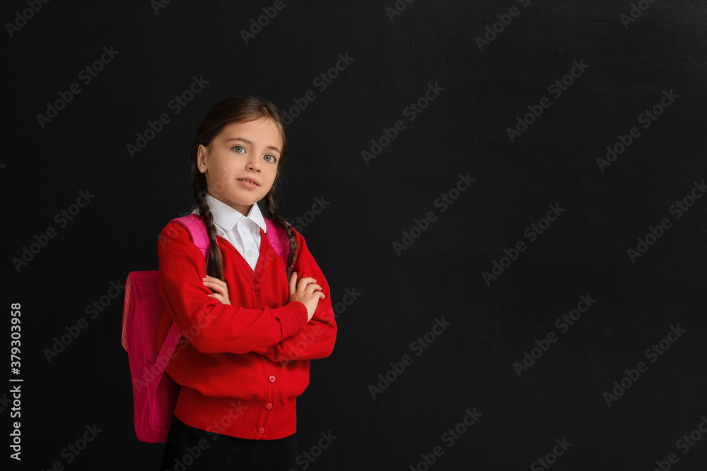 Little schoolgirl on dark background