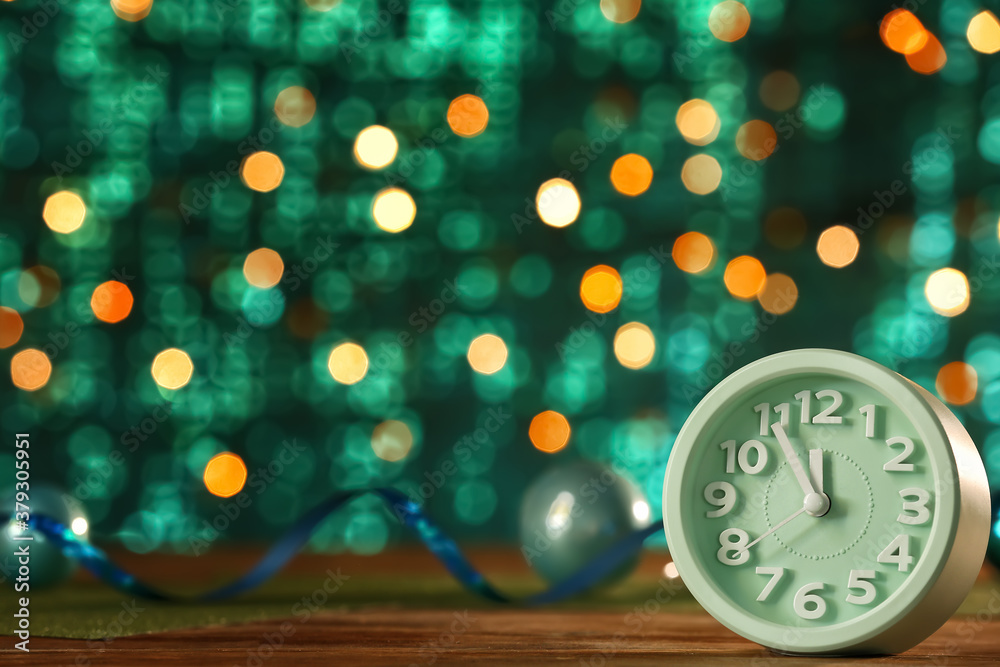 Clock on table against blurred lights. Christmas time