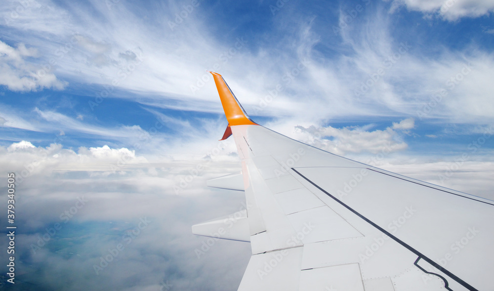 Wing of an airplane flying above the  clouds