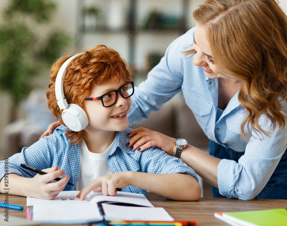 Mother helping child with homework and looks  at each other at home.