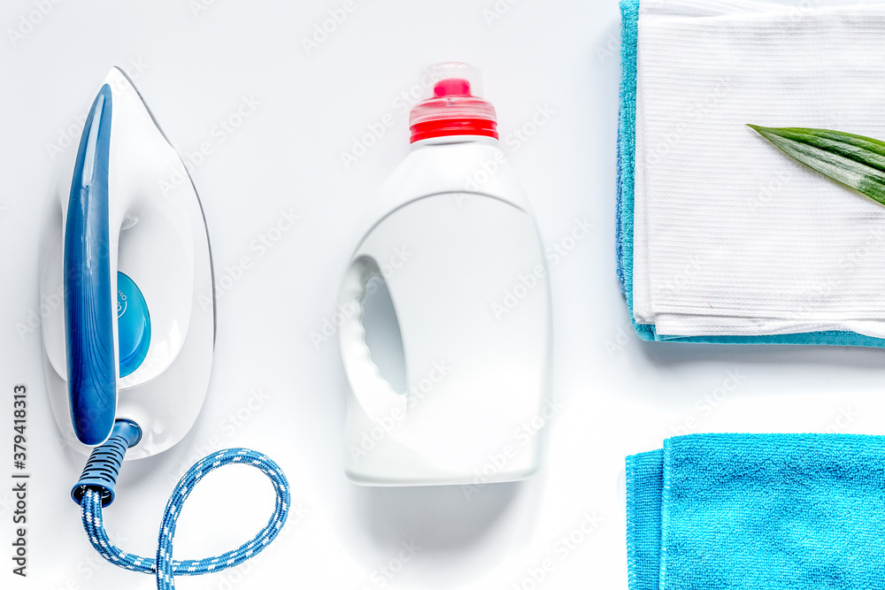 Launry set with towels and iron on white background top view