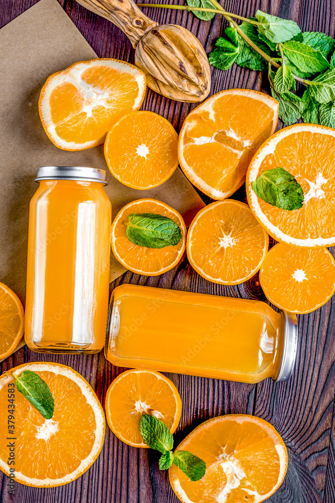 Orange juice in bottle with slices and mint on table top view