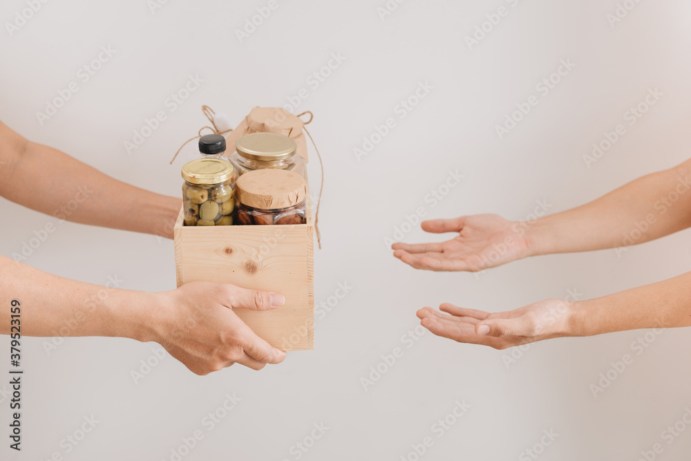 Donation box with various food. A volunteer passes a cardboard box with dry cereals, canned goods, e