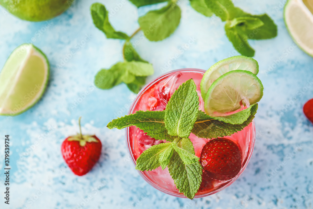 Glass of fresh strawberry mojito on color background