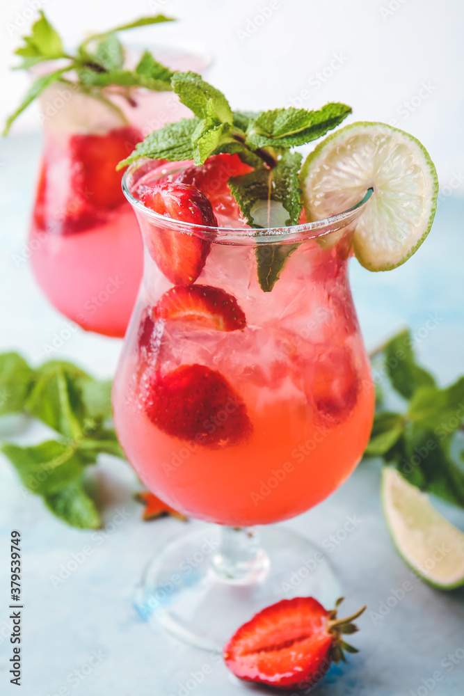 Glass of fresh strawberry mojito on color background