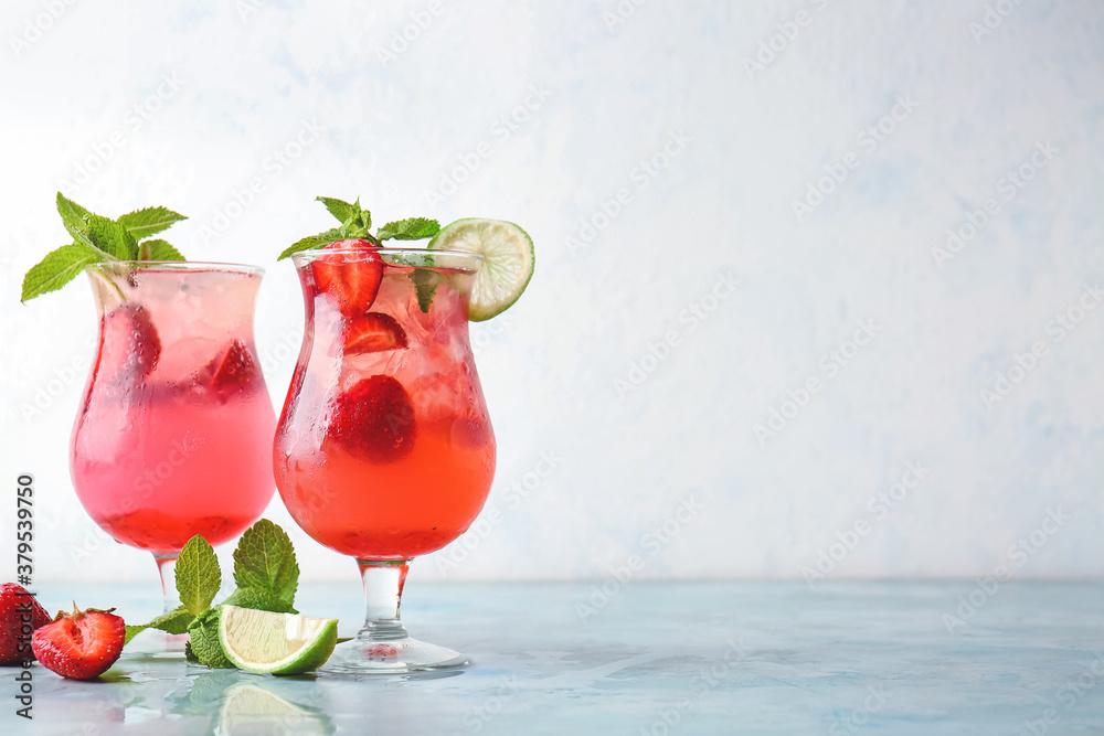 Glasses of fresh strawberry mojito on table