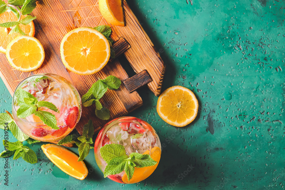 Glasses of fresh strawberry mojito on color background