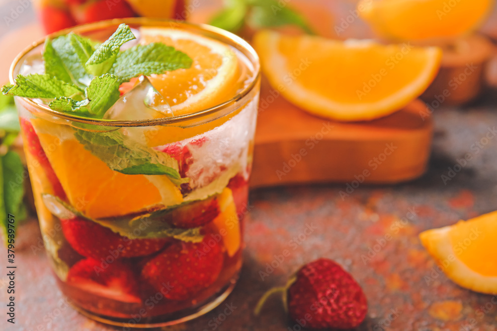 Glass of fresh strawberry mojito on color background, closeup