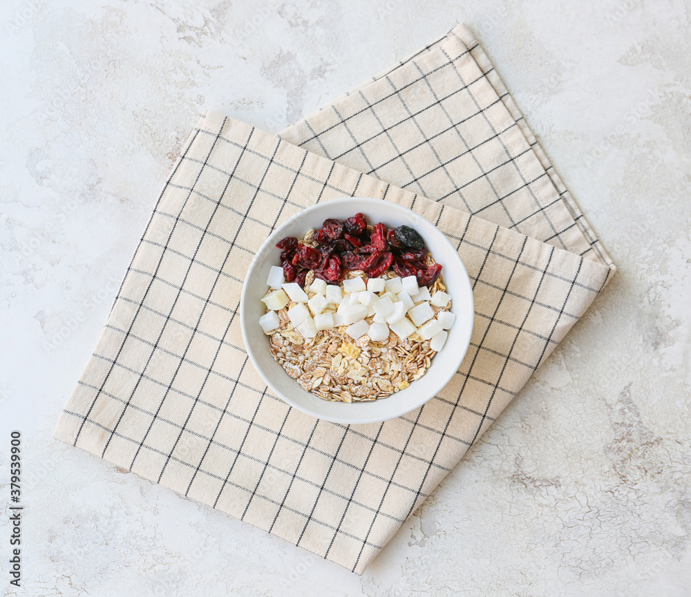 Bowl with tasty sweet oatmeal on light background