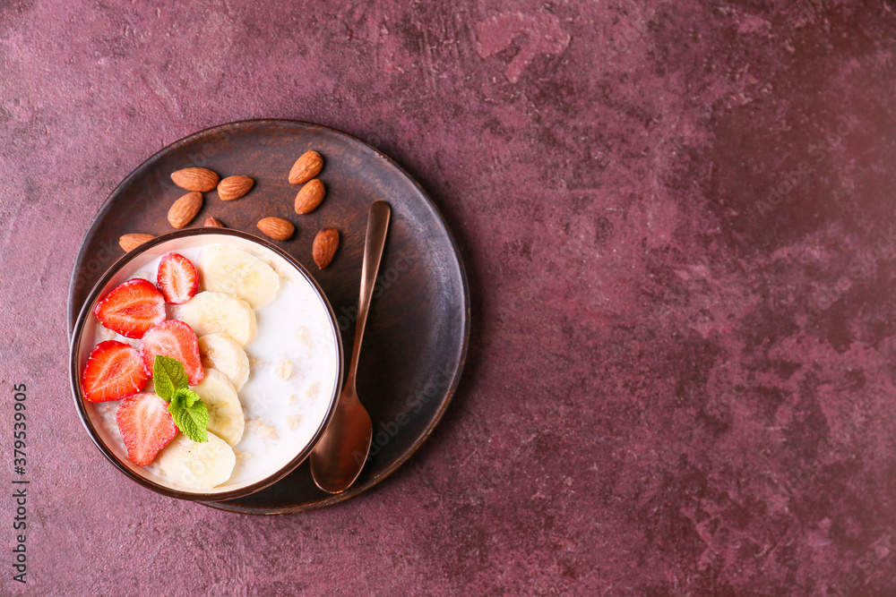 Bowl with tasty sweet oatmeal on color background