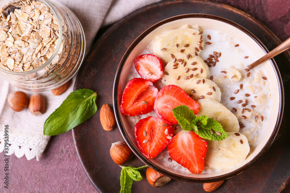 Bowl with tasty sweet oatmeal on table