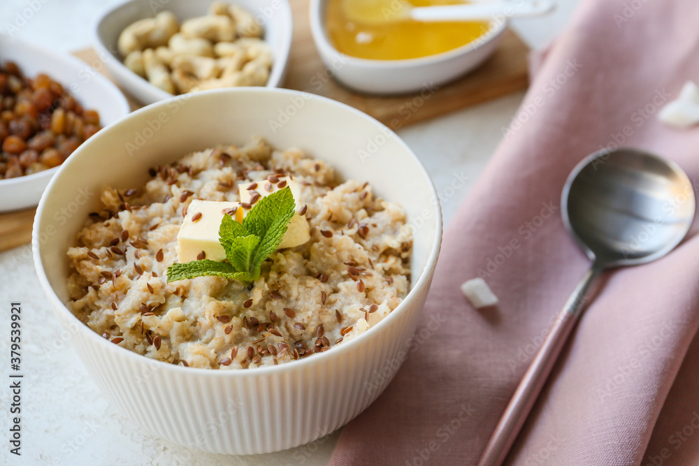 Bowl with tasty sweet oatmeal on table