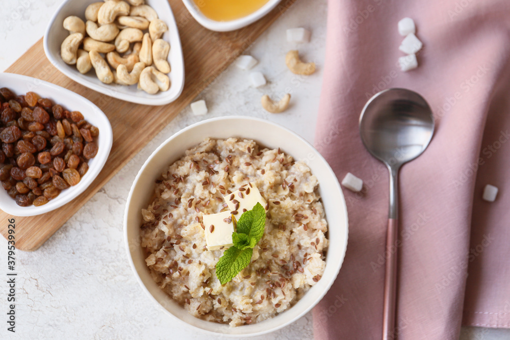 Bowl with tasty sweet oatmeal on table