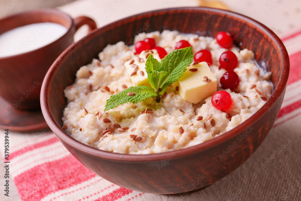 Bowl with tasty sweet oatmeal on table