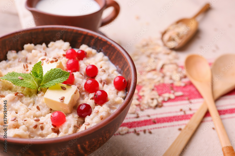 Bowl with tasty sweet oatmeal on table