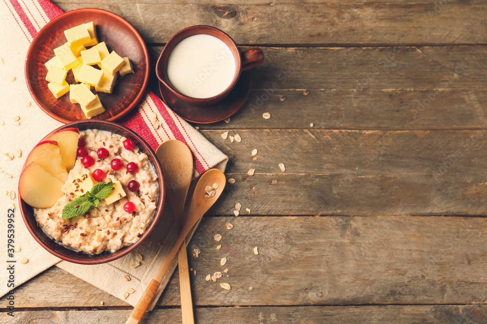 Bowl with tasty sweet oatmeal on table