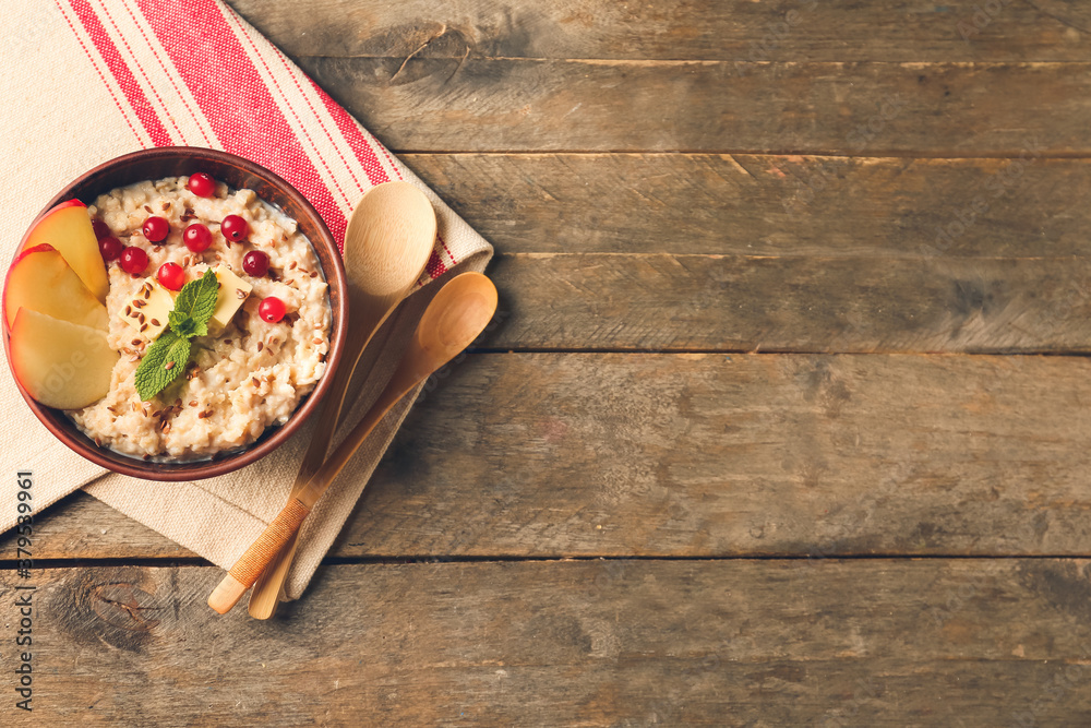 Bowl with tasty sweet oatmeal on table