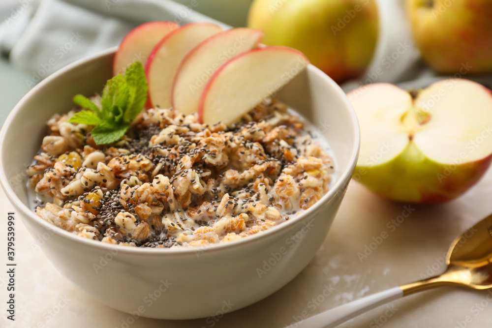 Bowl with tasty sweet oatmeal on table