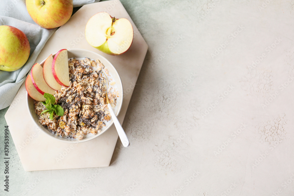 Bowl with tasty sweet oatmeal on light background