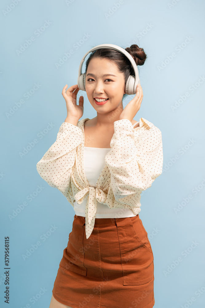 joyful asian woman wearing headphone and listening music from app in smartphone.