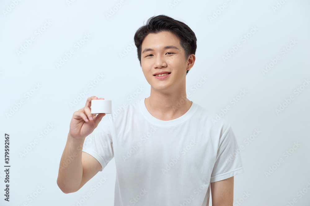 Amazing man advising recommendation buy, holding facial cream isolated grey background