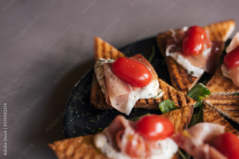 Finger food, toast with ham and tomato.