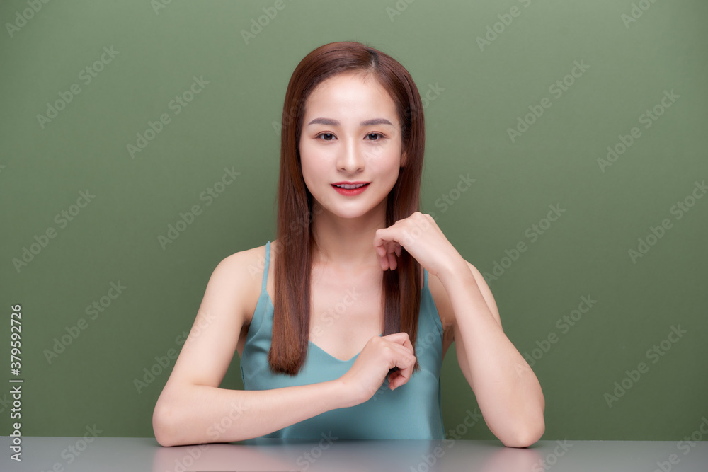 Asian women touch her hair on green background.