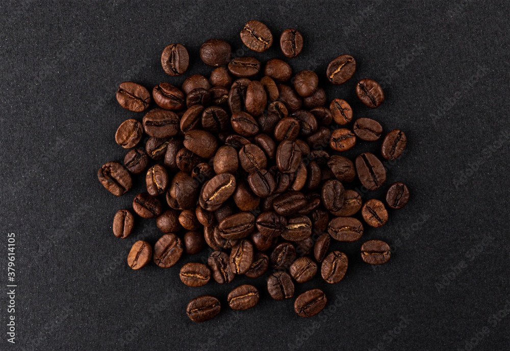 Heap of roasted coffee beans on black background