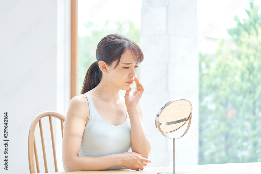 美容　鏡を見て悩む女性