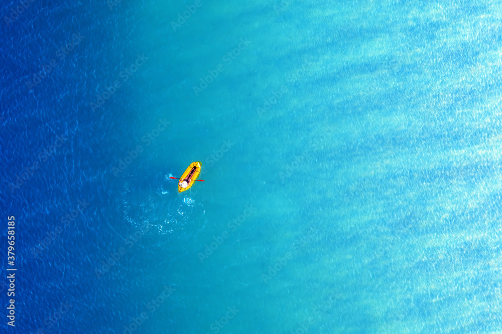 Yellow packraft rubber boat and turquoise water waves from top view. Active travel summer vacations 