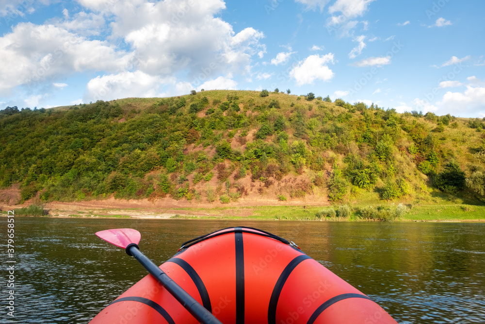 Orange packraft rubber boat on a river. Packrafting. Active lifestile concept