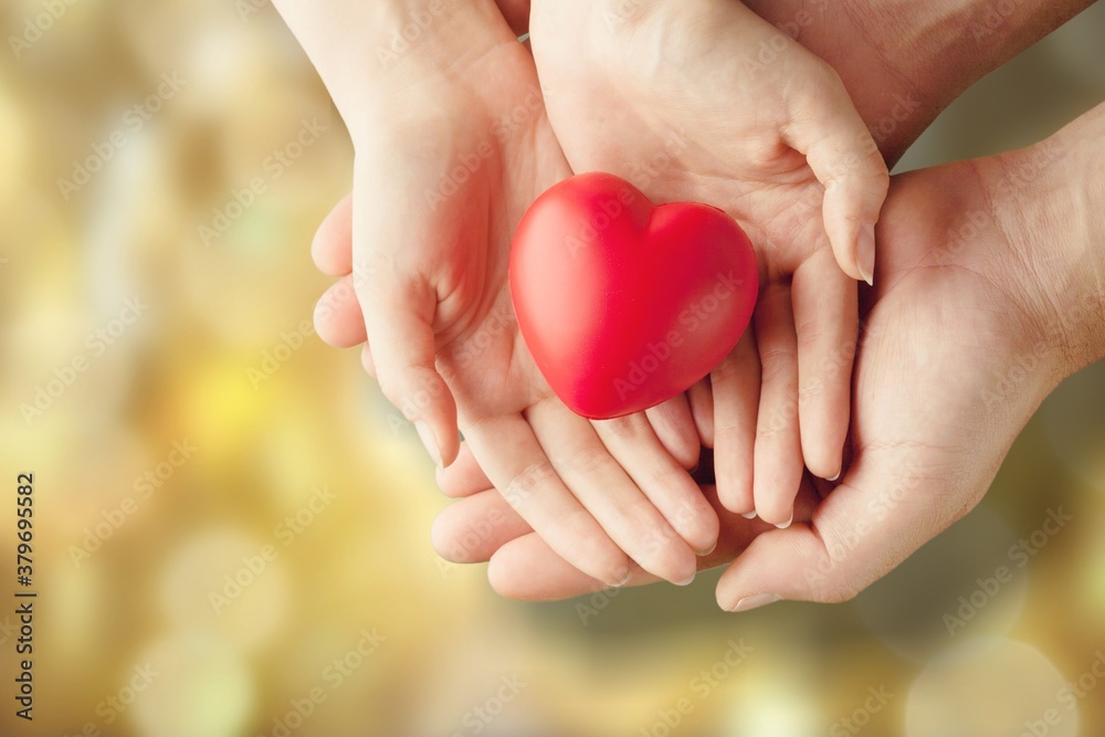 Man and woman holding red heart on background