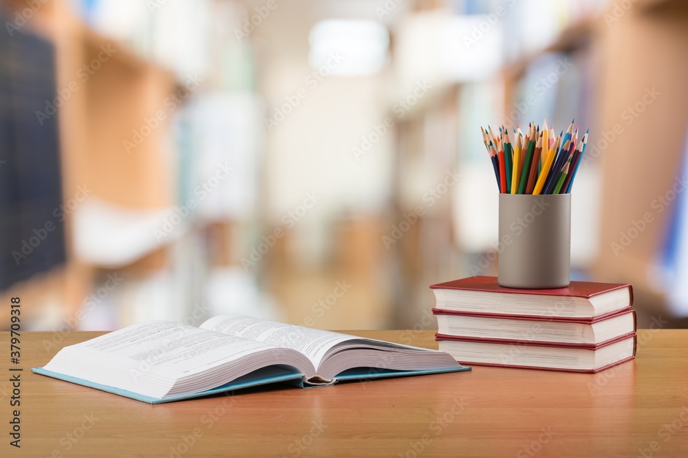 Stack school books with colorful pencils on a desk