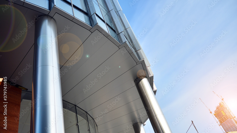 Office building, details of blue glass wall and sun reflections.